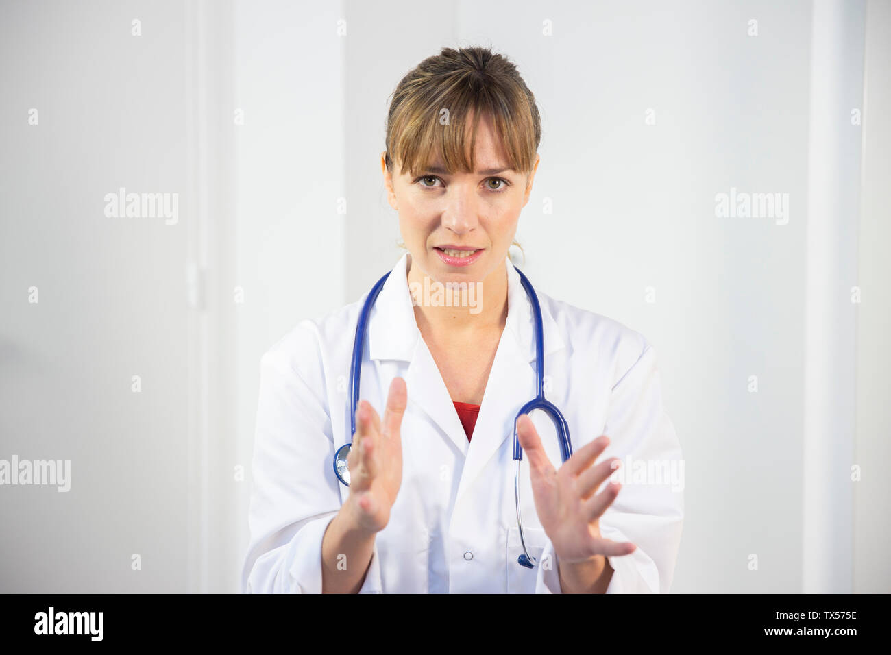 Un medico di sesso femminile nel suo mantello bianco Foto Stock