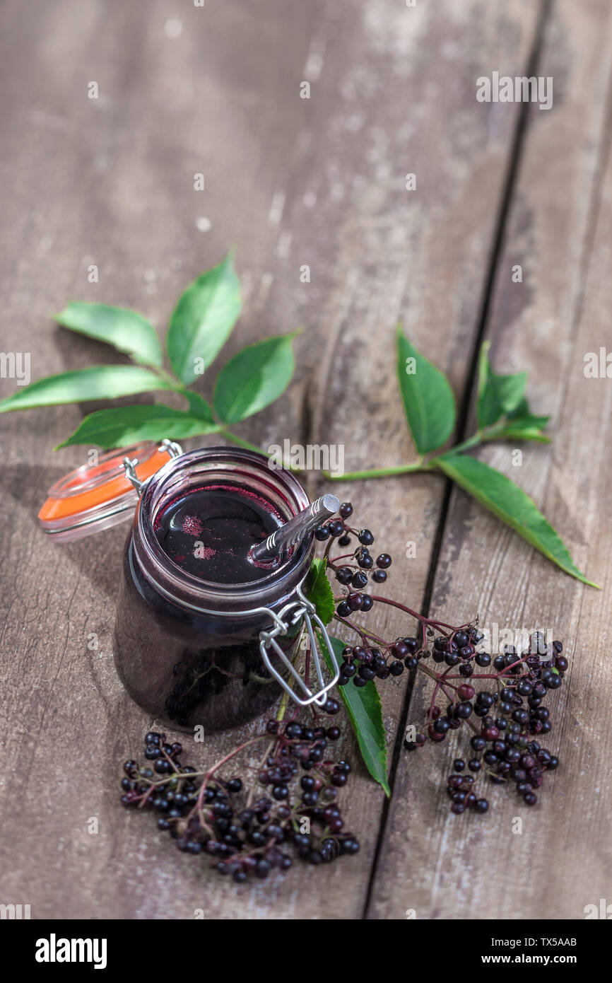 Marmellata di bacche di sambuco. Vasetto di fatti in casa confettura di  bacche di sambuco e frutta fresca sul vecchio sfondo di legno Foto stock -  Alamy