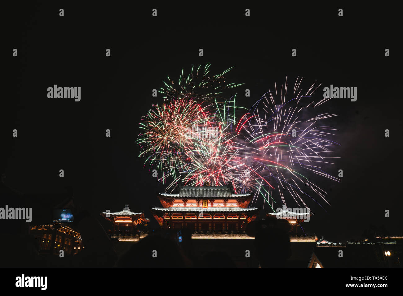 Fuochi d'artificio blooming cinese sopra gli antichi edifici Foto Stock