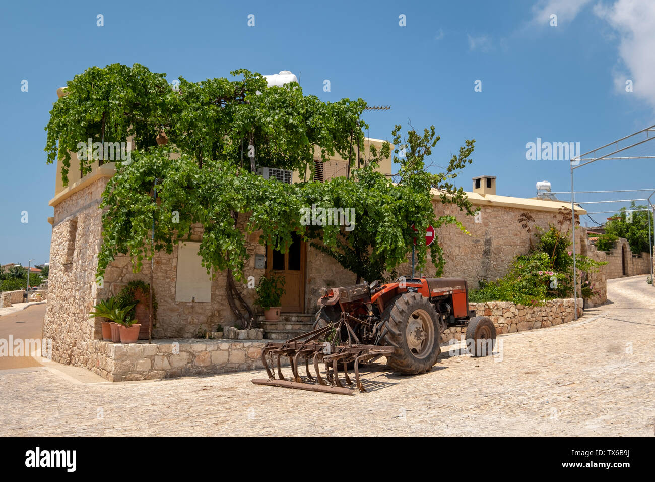 Un trattore parcheggiato al di fuori di una casa nel villaggio Ineia, regione di Paphos, Cipro. Foto Stock
