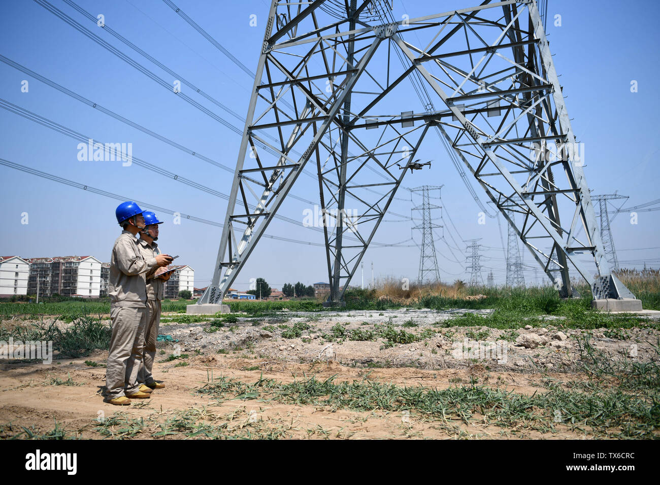 (190624) -- TIANJIN, Giugno 24, 2019 (Xinhua) -- Un ingegnere opera un drone per ispezionare le linee elettriche in alta tensione nel nord della Cina di Tianjin, Giugno 24, 2019. (Xinhua/Li Ran) Foto Stock