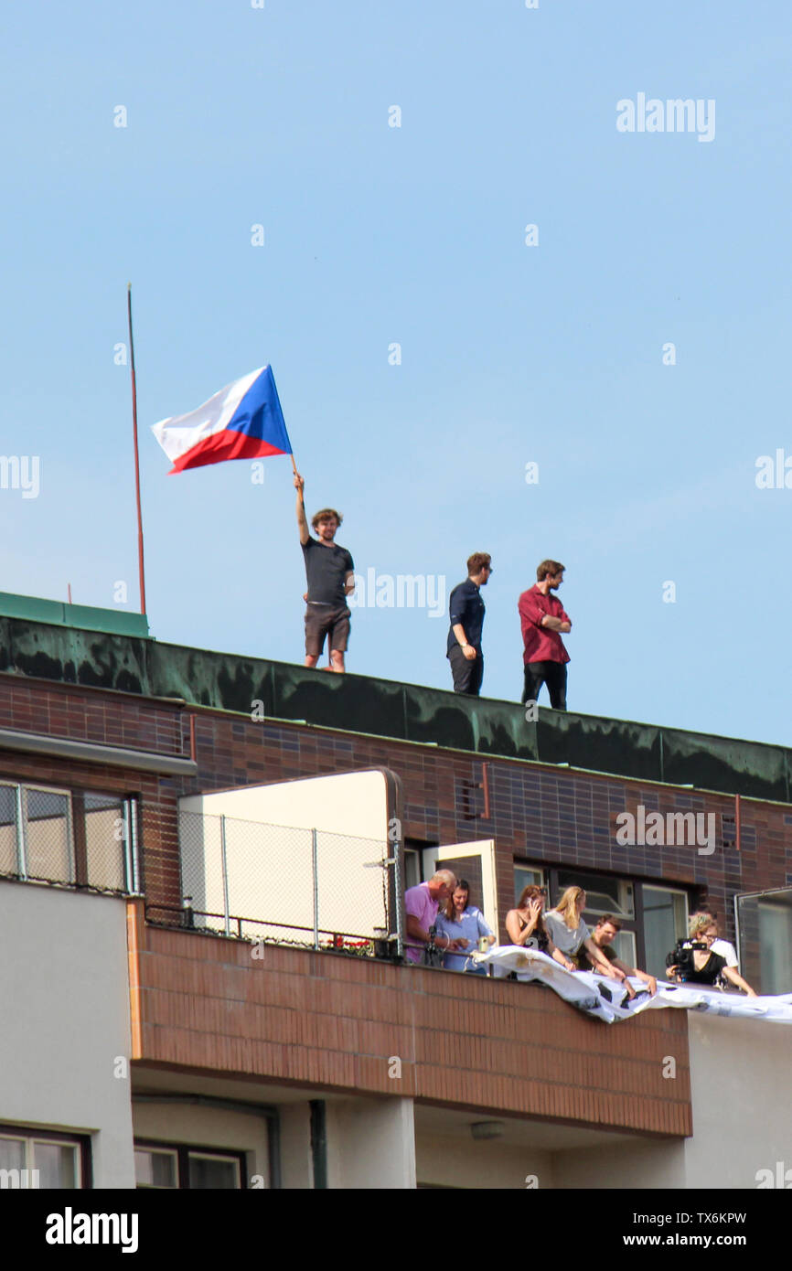 Praga, Repubblica Ceca - 23 Giugno 2019: persone su un tetto di un edificio il supporto di proteste contro il Primo Ministro Babis e ministro della Giustizia sulla Letna, Letenska piano. Dimostrazione, bandiera Ceca. Foto Stock