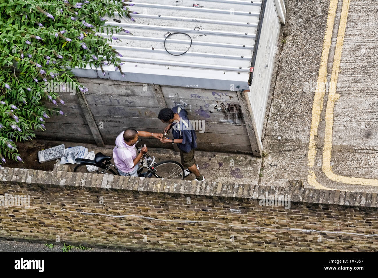 Il trafficante di droga nell'atto del passaggio di farmaci a un cliente in South London street Foto Stock