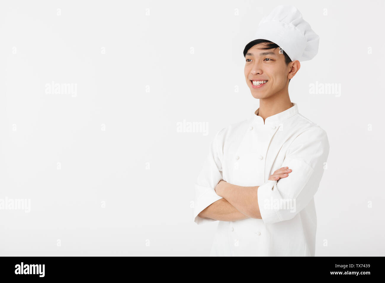Ritratto di giovane uomo cinese in bianco uniforme cuoco e chef hat sorridente in telecamera rimanendo isolate su sfondo bianco Foto Stock Ritratto di giovane uomo cinese in bianco uniforme cuoco e chef hat sorridente in telecamera rimanendo isolate su sfondo bianco Foto Stock