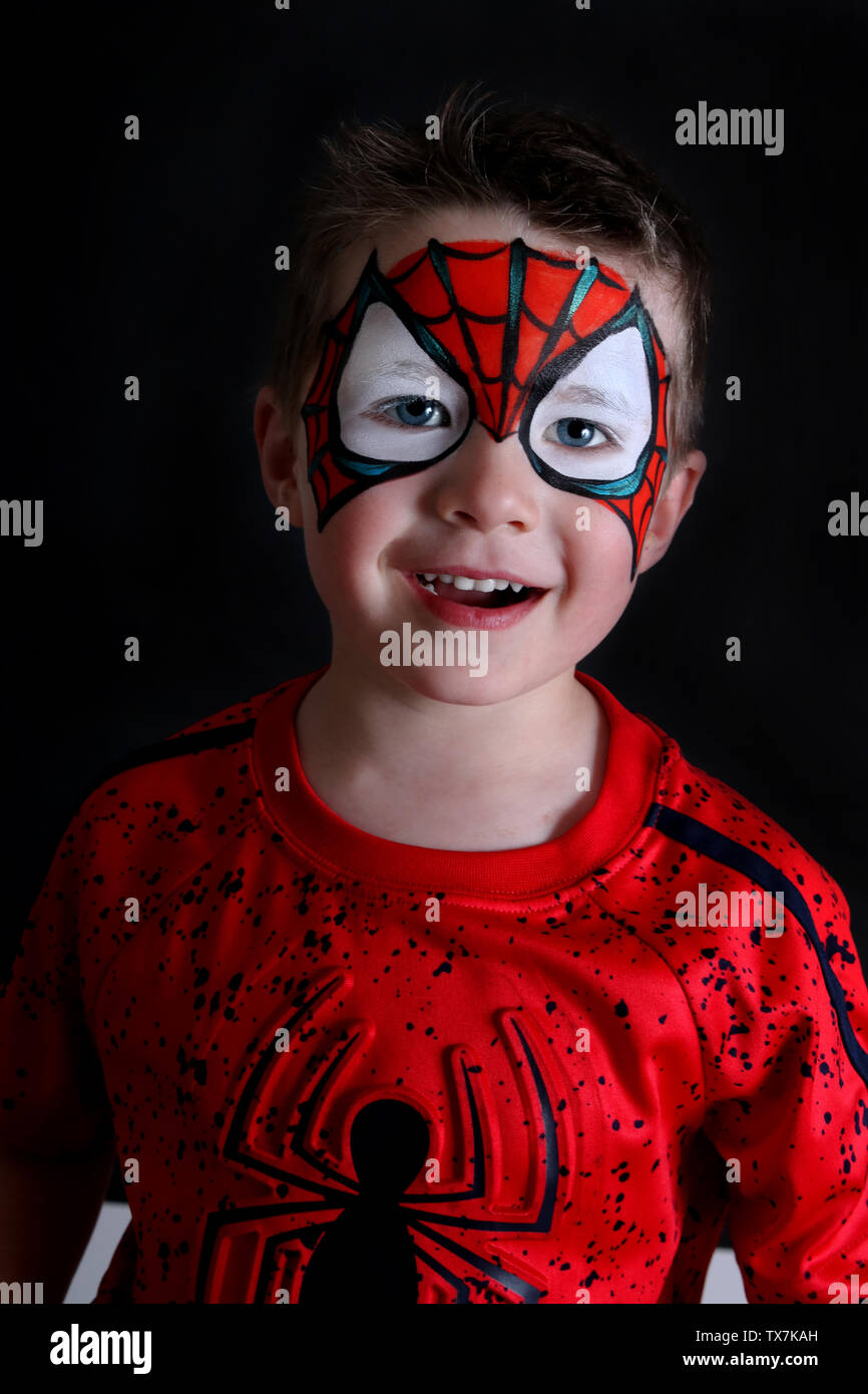 Il toddler boy con spider-man faccia sorridente di vernice Foto Stock
