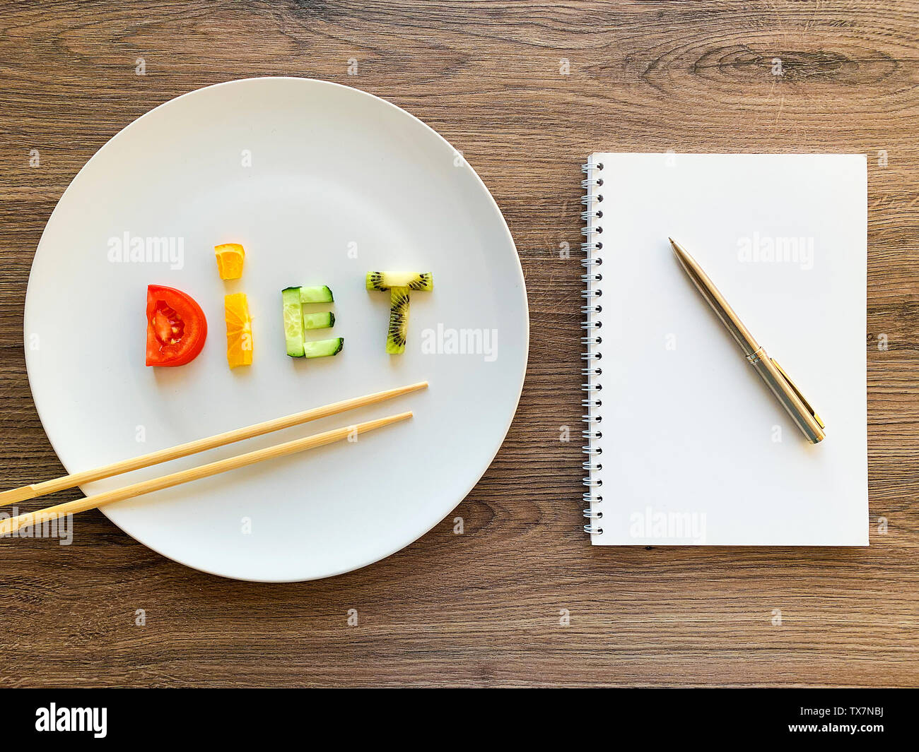 Parola dieta fatta di verdure a fettine in piastra bianca e la dieta piano su uno sfondo di legno Foto Stock