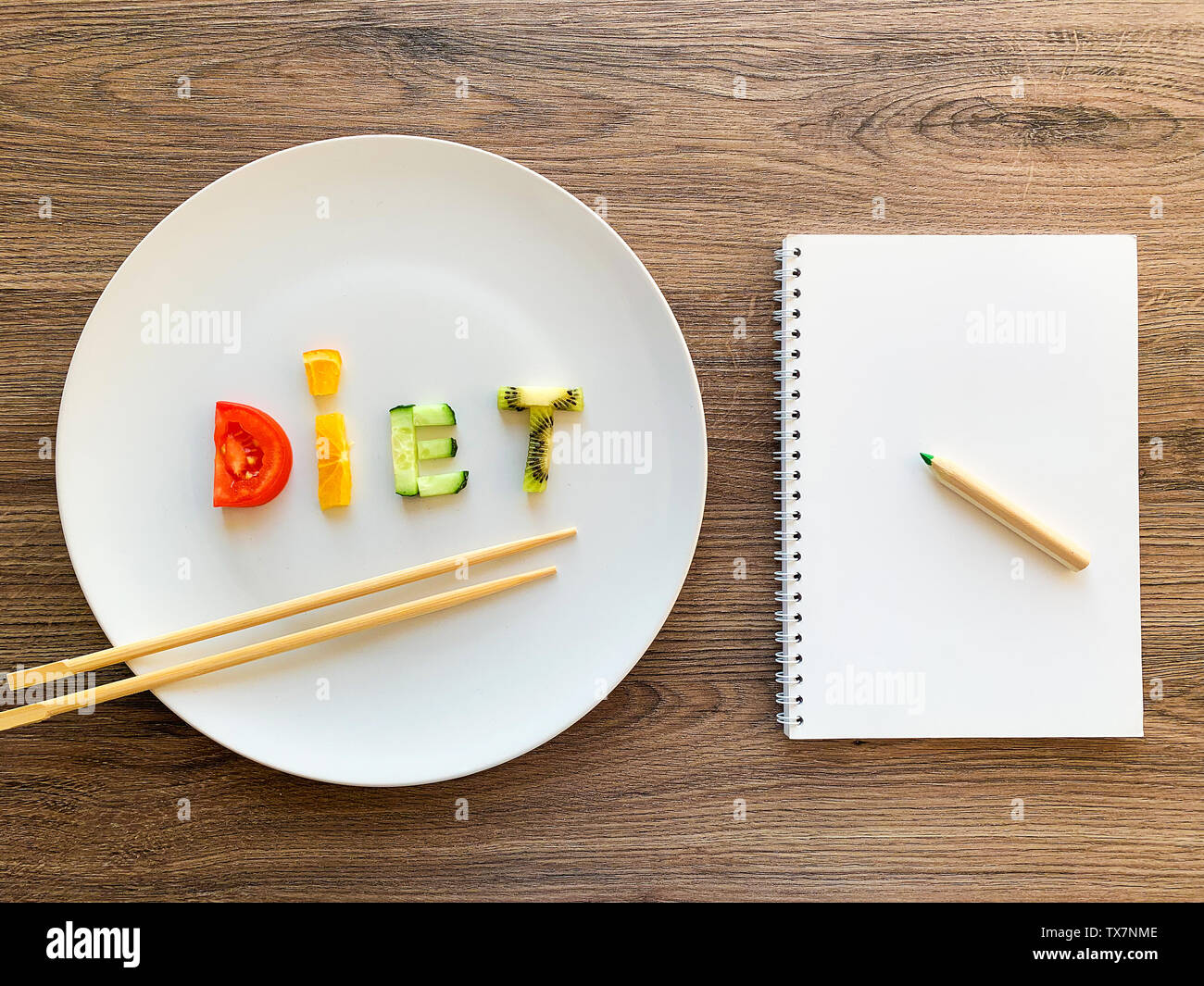 Parola dieta fatta di verdure a fettine in piastra bianca e la dieta piano su uno sfondo di legno Foto Stock