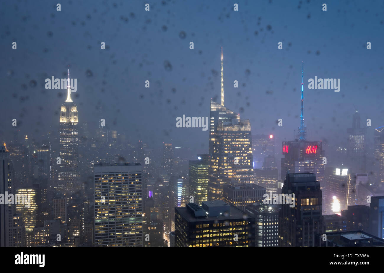 Manhattan skyline della città attraverso un sensore pioggia opener finestra la notte, New York, Stati Uniti d'America Foto Stock