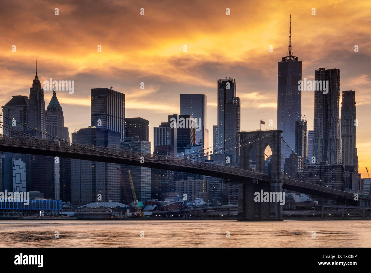 Il Ponte di Brooklyn, a est del fiume e dello skyline di Manhattan al tramonto, New York, Stati Uniti d'America Foto Stock