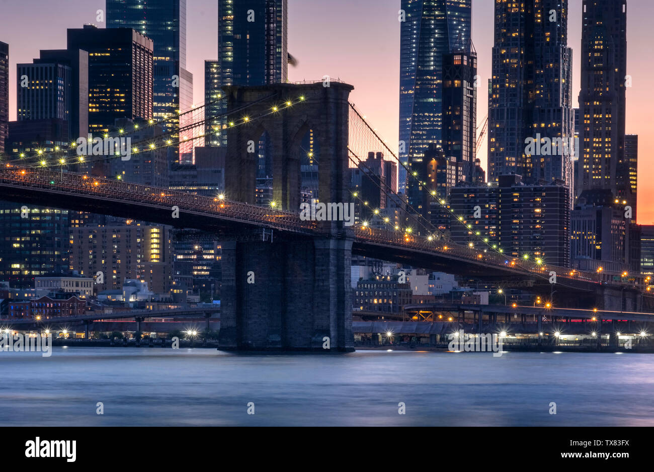 Il Ponte di Brooklyn oltre l'East River al tramonto, New York, Stati Uniti d'America Foto Stock
