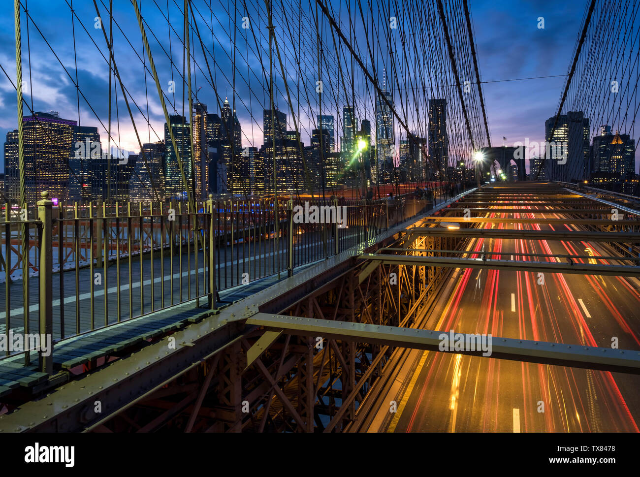 Il traffico che attraversa il ponte di Brooklyn a notte sostenuta da skyline di Manhattan, New York, Stati Uniti d'America Foto Stock