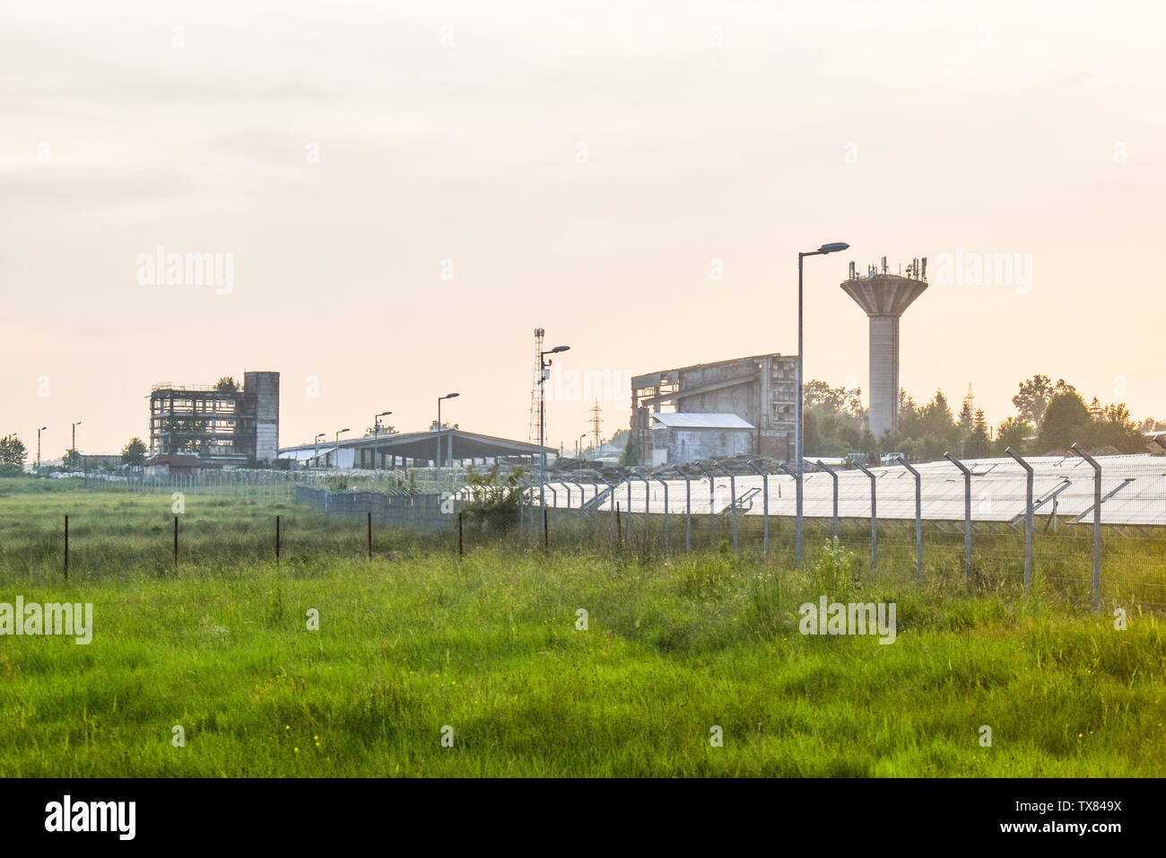 Tramonto su una potenza fotovoltaico impianto con moduli fotovoltaici per le energie rinnovabili sul campo. Solar Impianti per la generazione di energia elettrica costruita con l'Europa Foto Stock