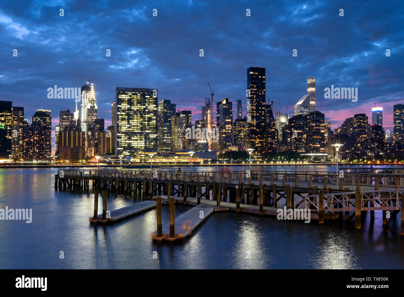 Skyline di Manhattan da Gantry Plaza del parco statale del molo di notte, New York, Stati Uniti d'America Foto Stock