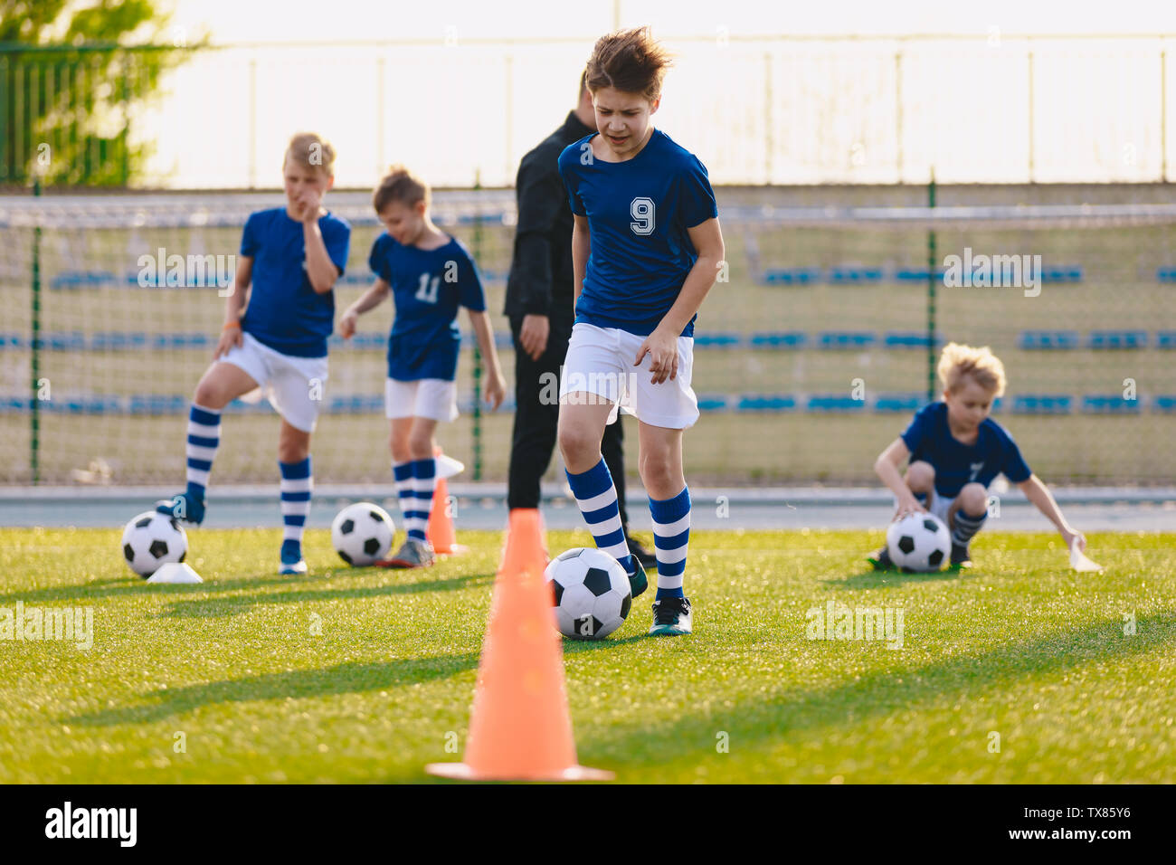 Soccer educazione fisica lezione. Bambini calcio formazione sul campo nelle scuole. Scuola attività atletiche. Sport educazione per i bambini e i giovani Foto Stock