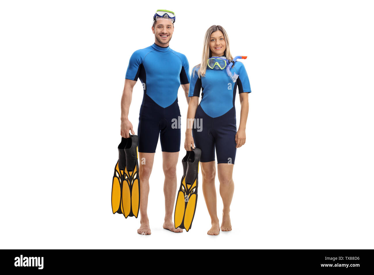A piena lunghezza Ritratto di una giovane coppia in neoprene, tenendo pinne e sorridente alla telecamera isolata su sfondo bianco Foto Stock