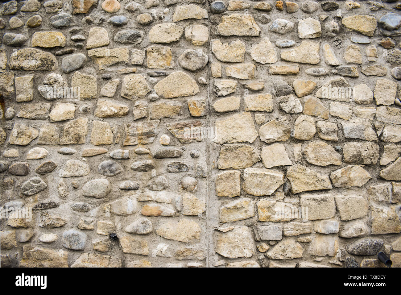 La texture di un muro di pietra. Il castello vecchio muro di pietra la texture dello sfondo. Muro di pietra come sfondo o texture. Parte di un muro di pietra, per sfondo o del testo Foto Stock