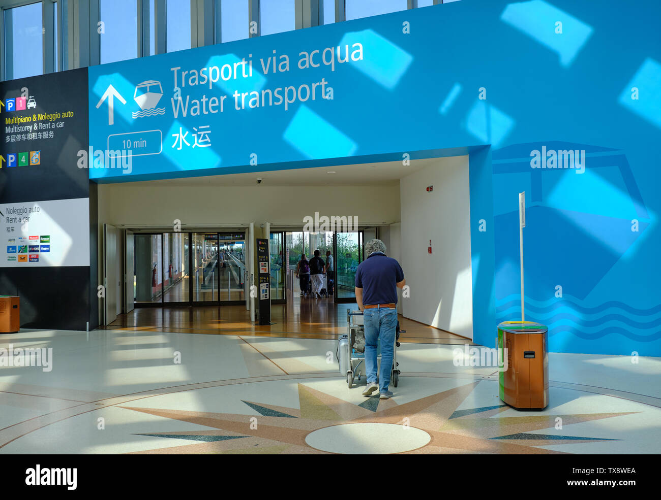 Turisti diretti in linkway tra l aeroporto e il trasporto di acqua il terminale per andare a Venezia, Italia - 16 giugno 2019 Foto Stock
