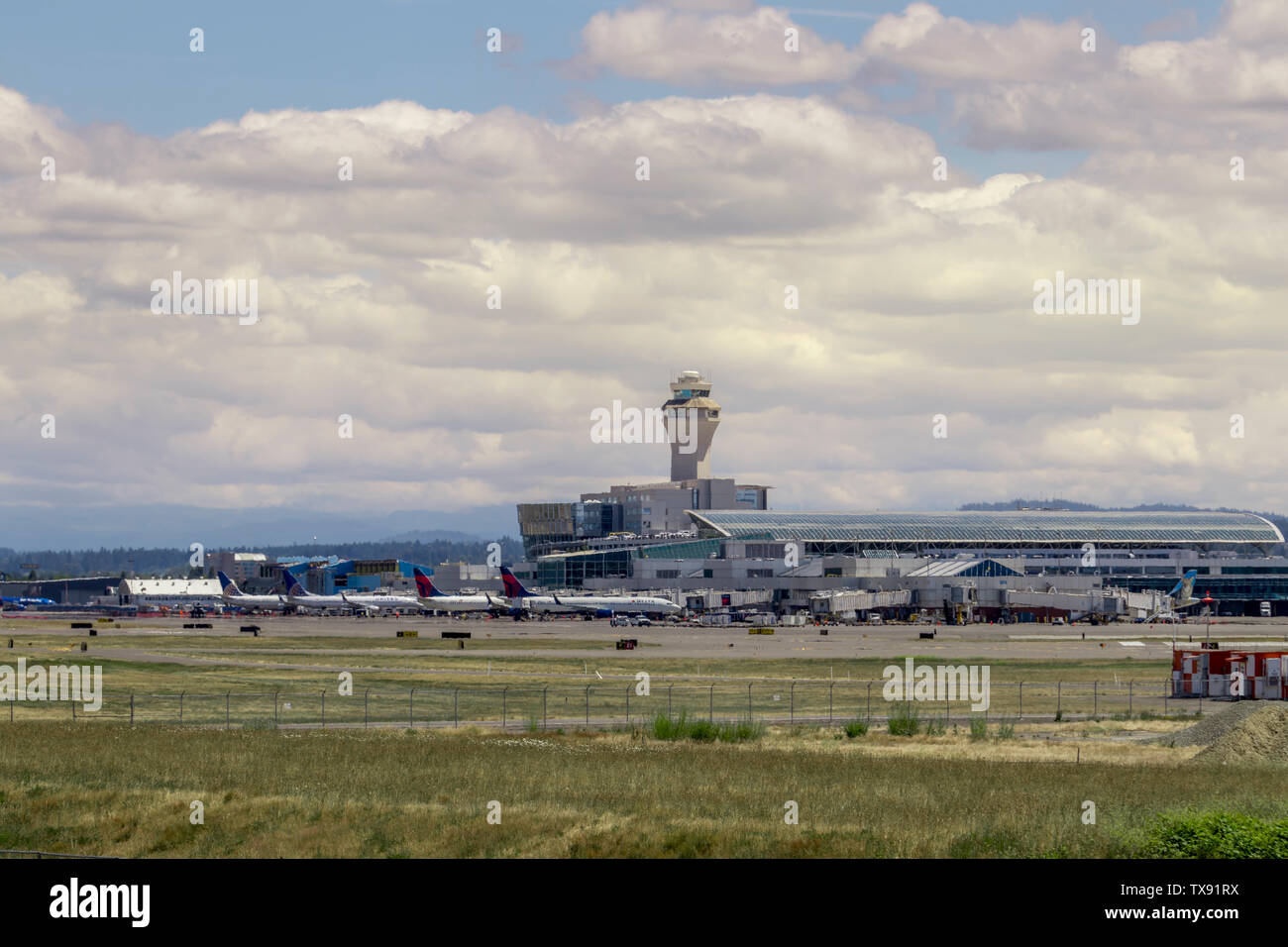 Portland, O / STATI UNITI D'AMERICA - Giugno 2019: aerei parcheggiati alle porte di attesa per i passeggeri a bordo all'Aeroporto Internazionale di Portland (PDX) su un bel d Foto Stock