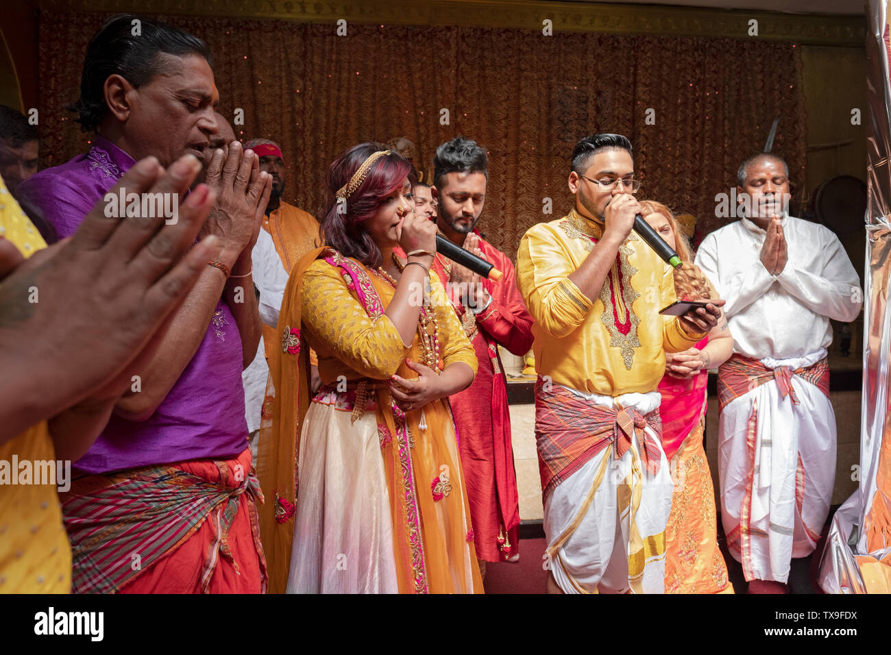 Devoti fedeli indù cantare durante un servizio per rendere grazie alla divinità. Nel Queens, a New York City. Foto Stock