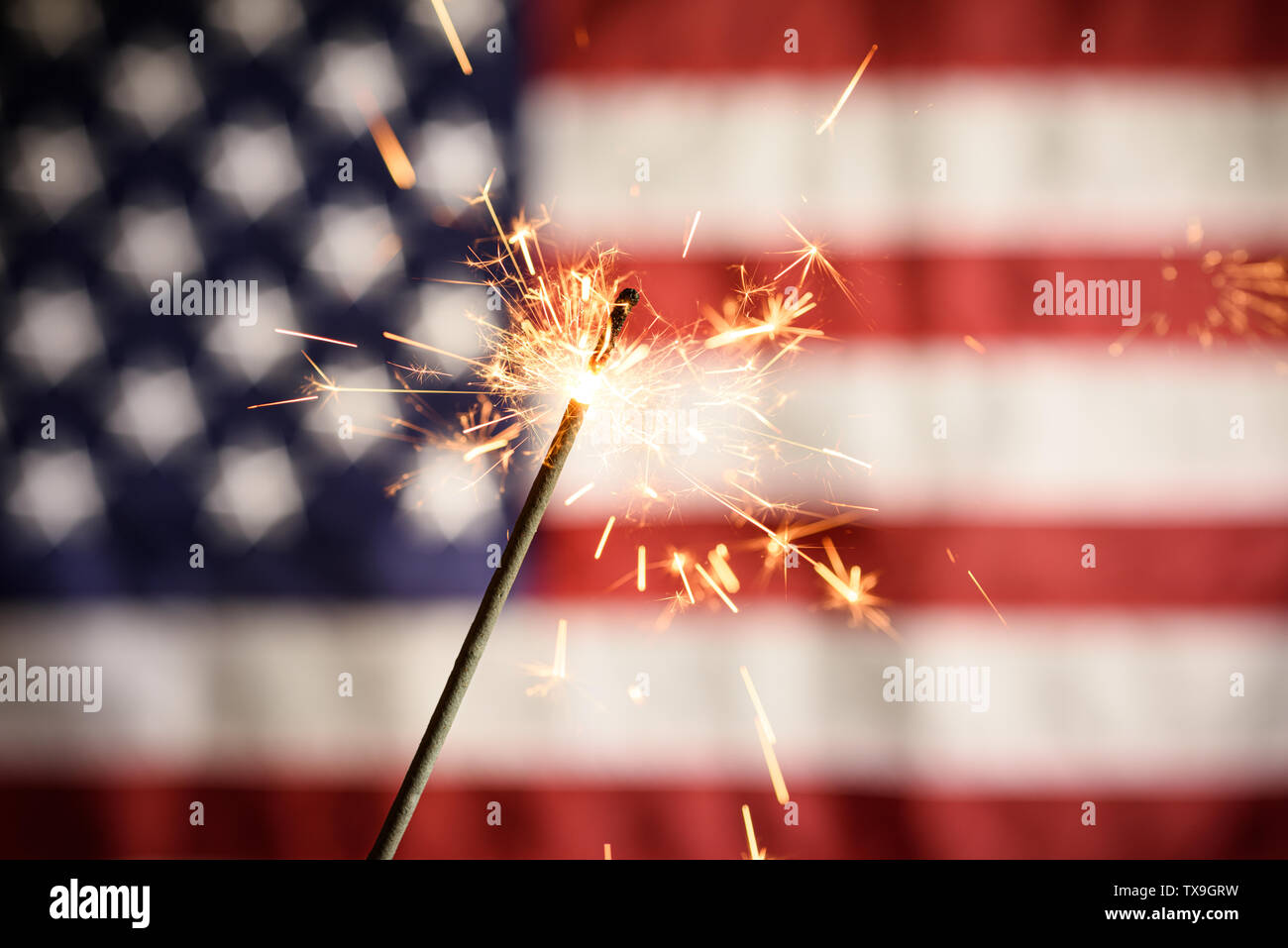 Sparkler Closeup con bandiera americana in background. Per celebrare il 4 luglio il Giorno di Indipendenza Foto Stock