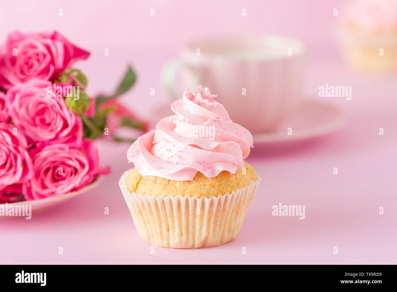 Tortina con crema rosa e Decorazione rose sul rosa pastello - sfondo romantico banner orizzontale per congratulazioni, biglietto di auguri per il compleanno, abbiamo Foto Stock