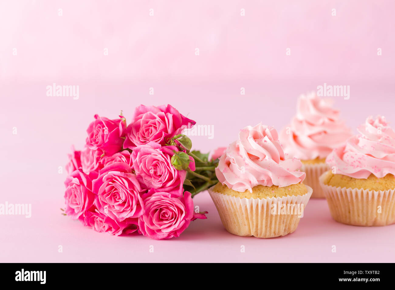 Tortina con crema rosa e Decorazione rose sul rosa pastello - sfondo romantico banner orizzontale per congratulazioni, biglietto di auguri per il compleanno, abbiamo Foto Stock