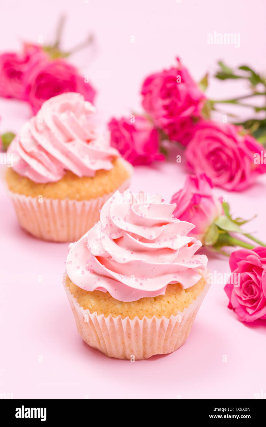 Tortina con crema rosa e Decorazione rose sul rosa pastello - sfondo romantico banner orizzontale per congratulazioni, biglietto di auguri per il compleanno, abbiamo Foto Stock