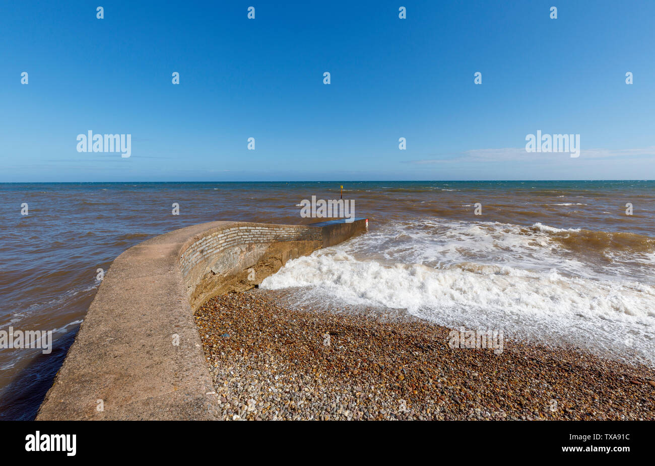 Struttura di frangionde in riva al mare a Sidmouth con onde, una piccola e rinomata costa sud cittadina balneare nel Devon, sud-ovest Inghilterra Foto Stock