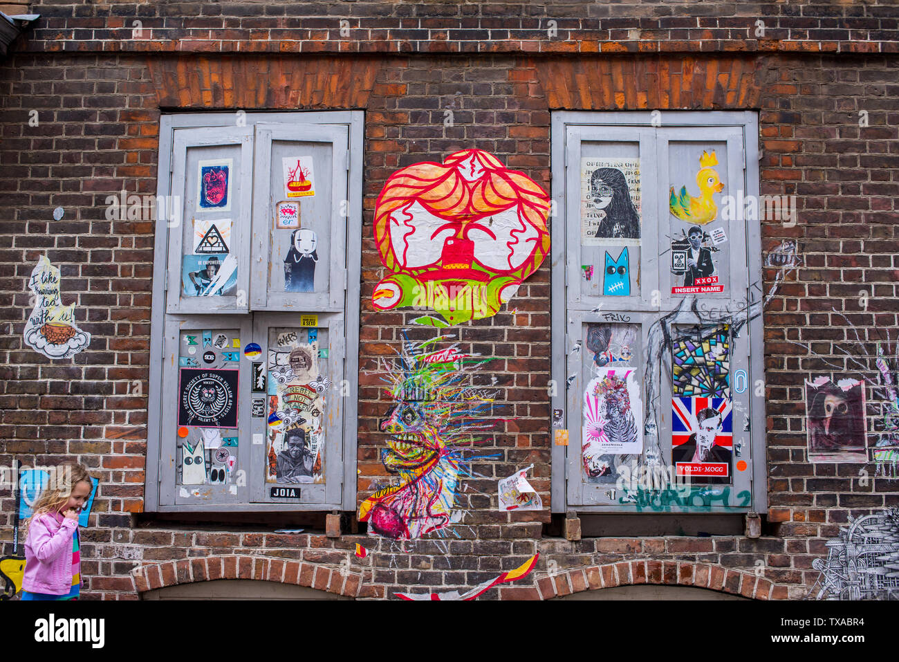 Due finestre chiuse coperto di graffiti murali di arte di strada in Brick Lane Shoreditch, Londra, Inghilterra Foto Stock