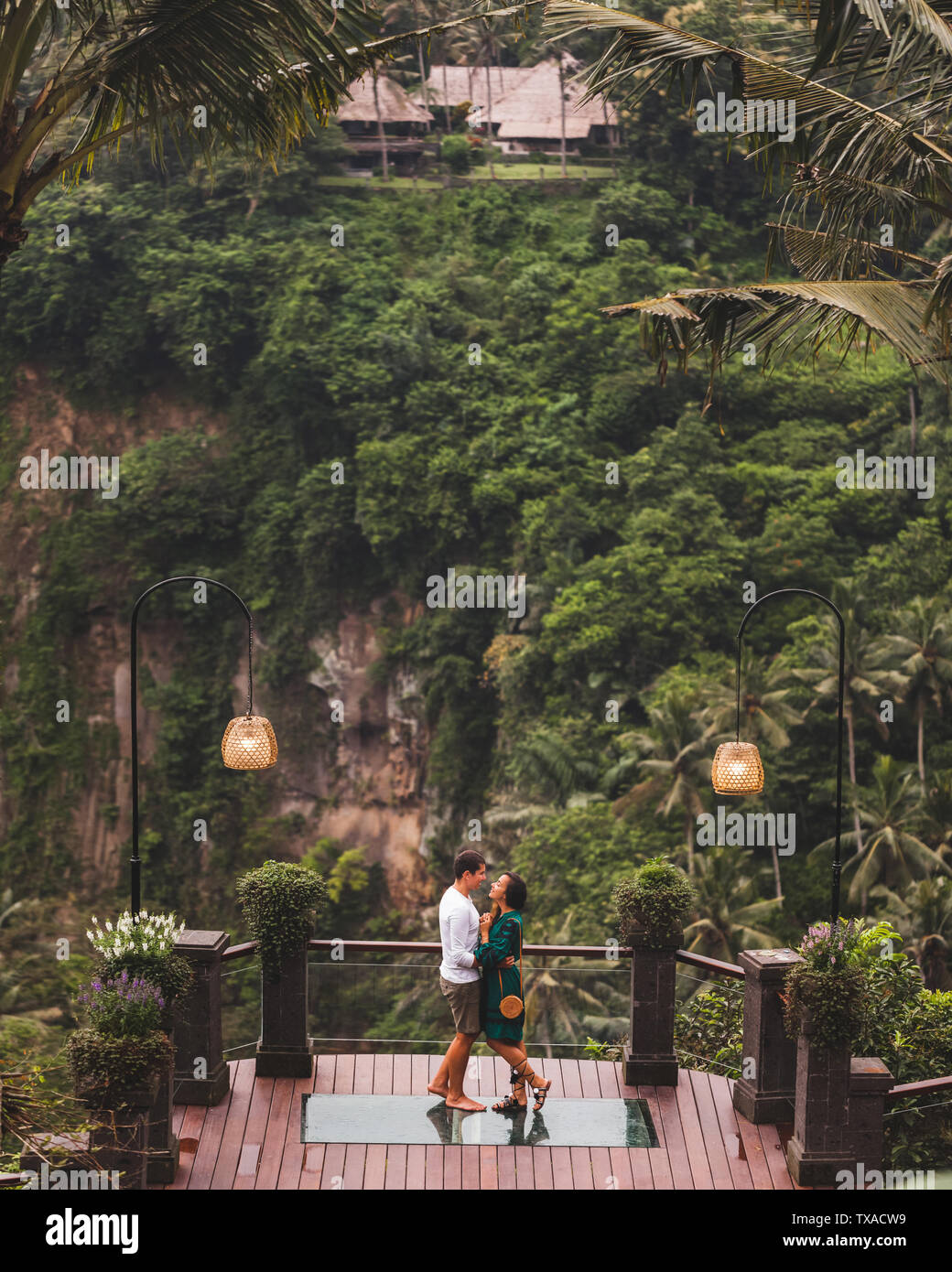 Coppia felice in amore godendo insieme sul balcone con straordinaria vista Giungla dalla scogliera in Ubud, Bali Foto Stock