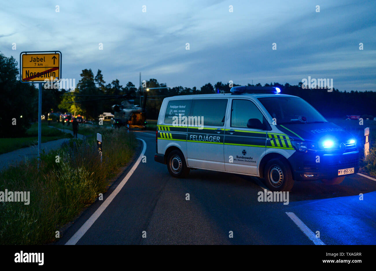 Nossentin, Germania. Il 24 giugno 2019. Un poliziotto militare sorge su una strada chiusa vicino a uno dei siti di crash di un Eurofighter. Dopo il crash di due Eurofighter aerei da combattimento nel Meclemburgopomerania occidentale, la sicurezza aerea generale delle forze armate tedesche ha ripreso le indagini sulle cause dell'incidente. Credito: Christophe Gateau/dpa/Alamy Live News Foto Stock