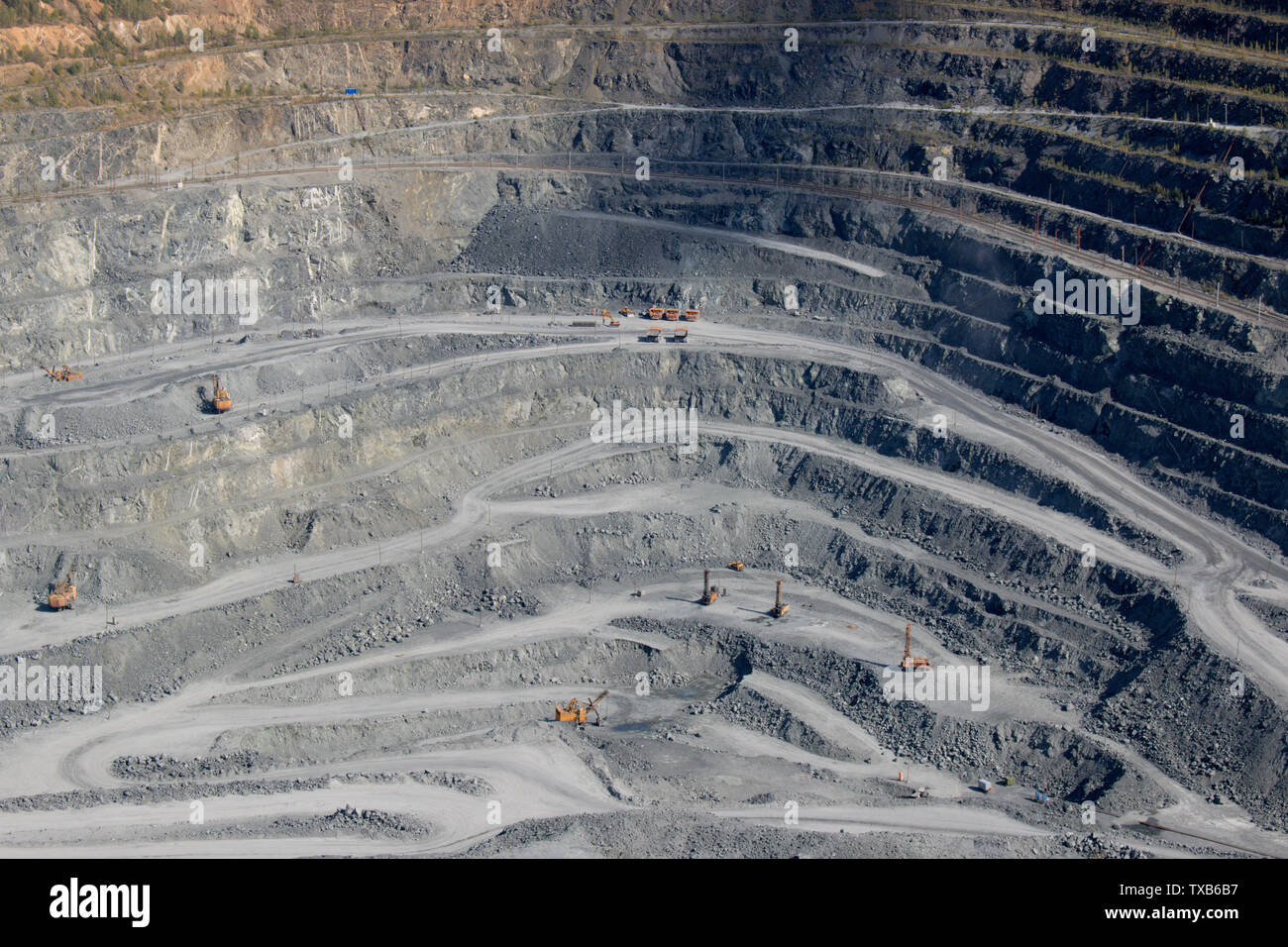 Vista aerea industriale a cielo aperto della cava di data mining con un sacco di macchinari al lavoro - vista dall'alto. Estrazione della calce, gesso, calx, caol Foto Stock