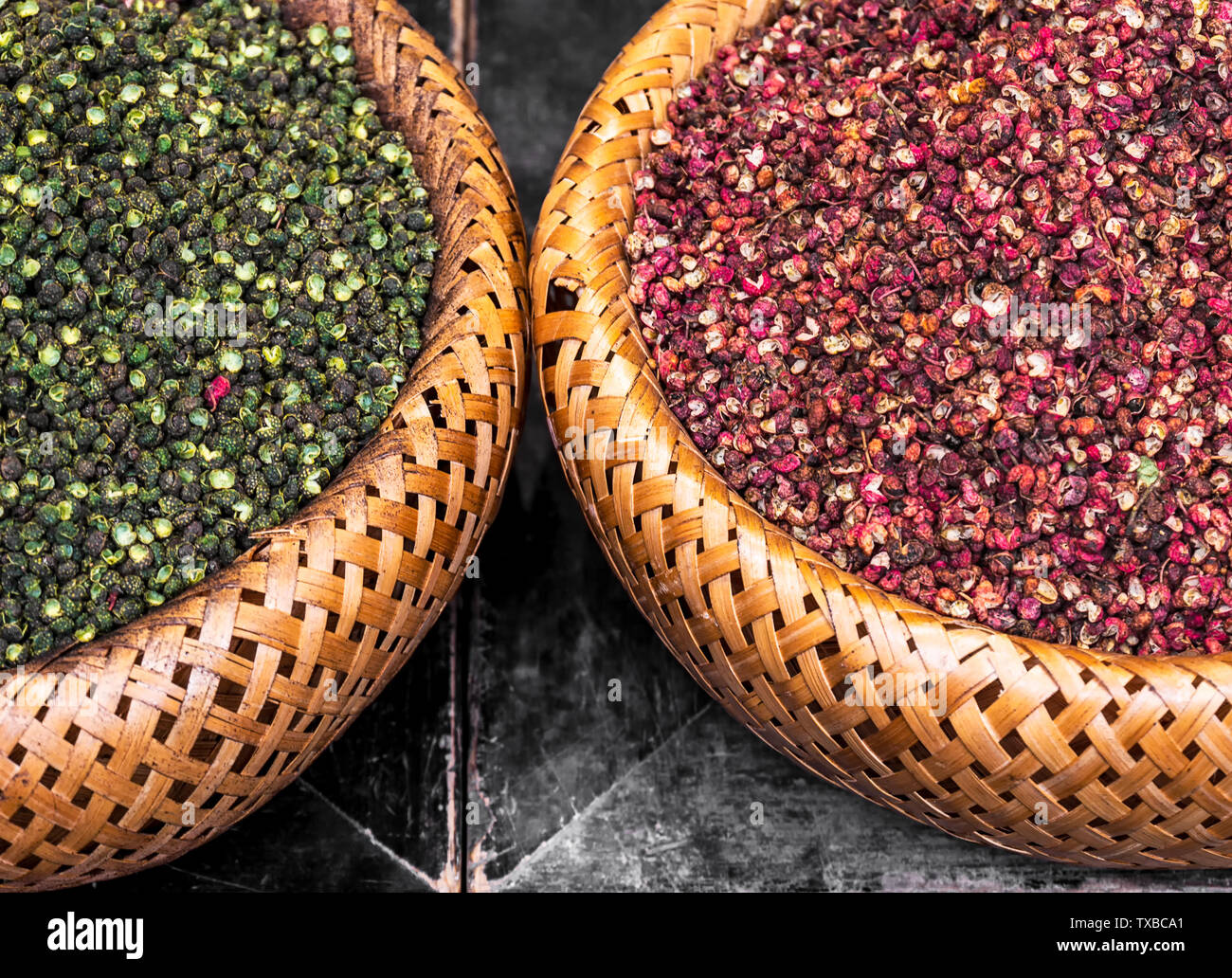 Il verde e il rosso pepe in una paletta di bambù. Foto Stock