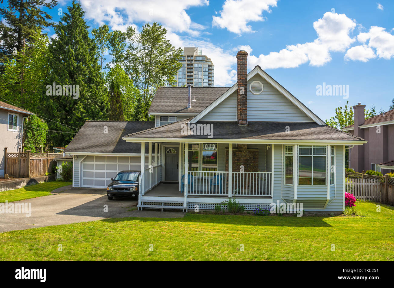Casa di famiglia con un piccolo patio e prato verde nella parte anteriore in area urbana di Vancouver Foto Stock