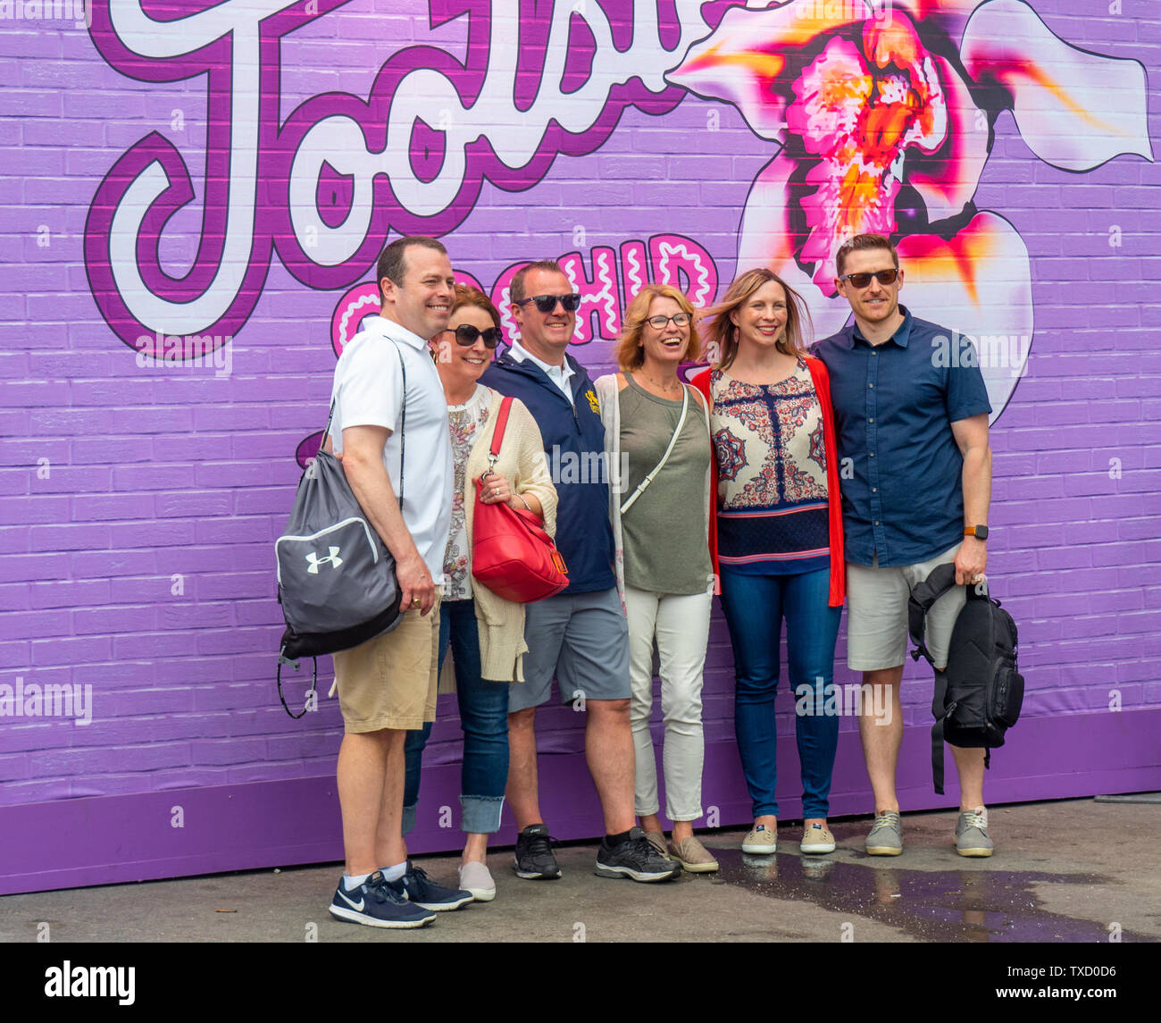 Turisti caucasici in posa per una fotografia di fronte Tootsies Orchid Lounge Ristorante e sala concerti a NFL Draft 2019 Nashville Tennessee negli Stati Uniti. Foto Stock
