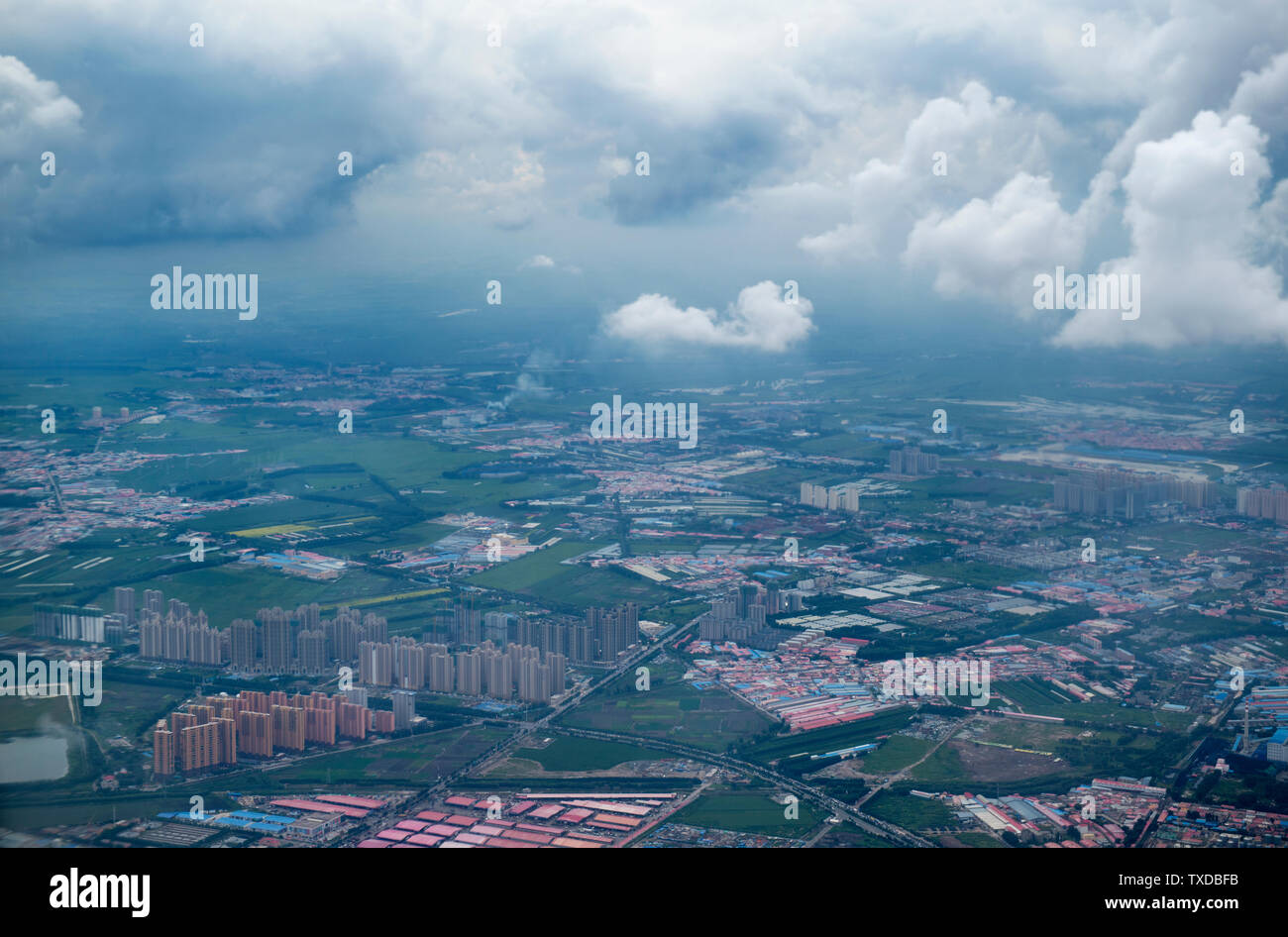 Riprese aeree di montagne, campi, villaggi, città sotto il cielo blu e nuvole bianche del fiume Heilongjiang Foto Stock