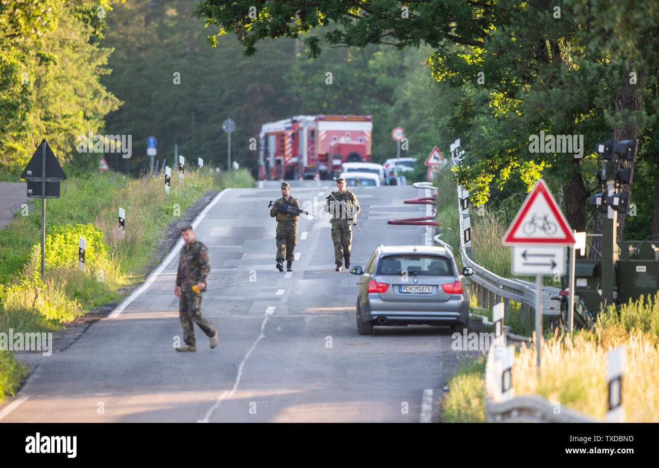 Nossentin, Germania. Il 25 giugno, 2019. Soldati a piedi vicino a uno dei siti di crash di un Eurofighter su una strada. Durante il combattimento aereo esercizi, due Eurofighter ha colliso oltre il Meclemburgo Lake District e si è schiantato vari chilometri di distanza. Entrambi i piloti ancora riuscito ad attivare i sedili di espulsione. Ma un pilota è stato ucciso. La seconda è sopravvissuto l' infortunio e stato ferito e portato in ospedale. Credito: Christophe Gateau/dpa/Alamy Live News Foto Stock