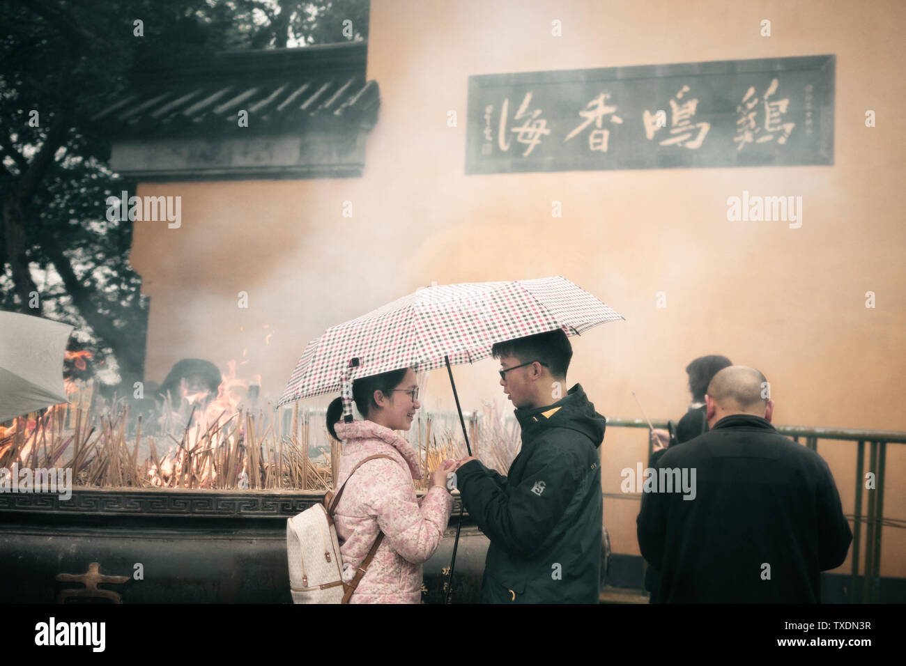 In antico tempio Jiming in Nanjing, una coppia stava entrando in fragranza, così ho registrato il momento dopo aver inserito la fragranza...... erano sotto un ombrello sotto la pioggia, così felicemente guardato ogni altro, il viso della ragazza è stata riempita con un sorriso, il ragazzo espressione era più una sorta di responsabilità e la responsabilità al momento della registrazione di otturatore, il mio cuore è stato spostato da questa forte emozione, augurando loro un vero amore per l'eternità in Foto Stock