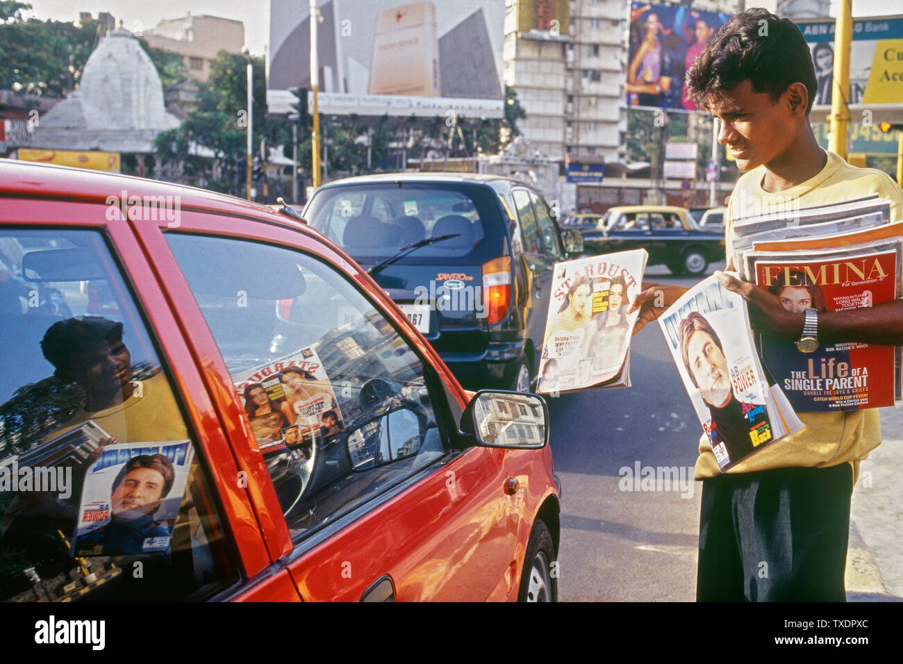 Ragazzo vendita di film di Bollywood riviste al traffico lo svincolo, Mumbai, Maharashtra, India, Asia Foto Stock