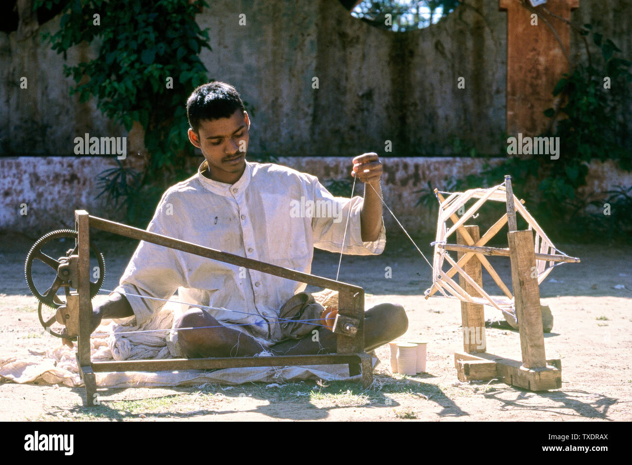 Ragazzo giovane la filatura dei filati di cotone sul charkha, Gujarat, India, Asia Foto Stock