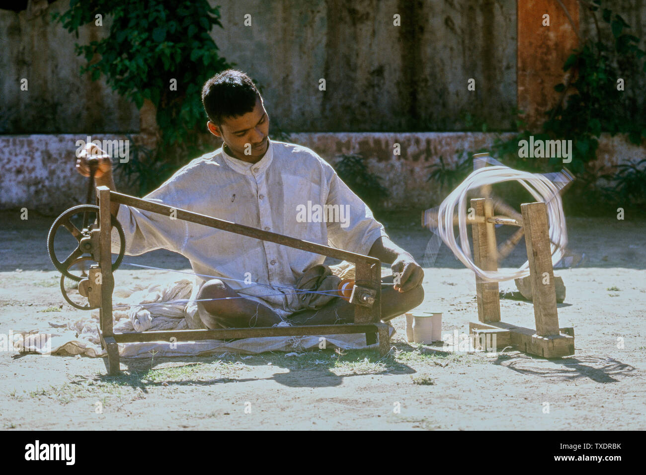 Ragazzo giovane la filatura dei filati di cotone sul charkha, Gujarat, India, Asia Foto Stock