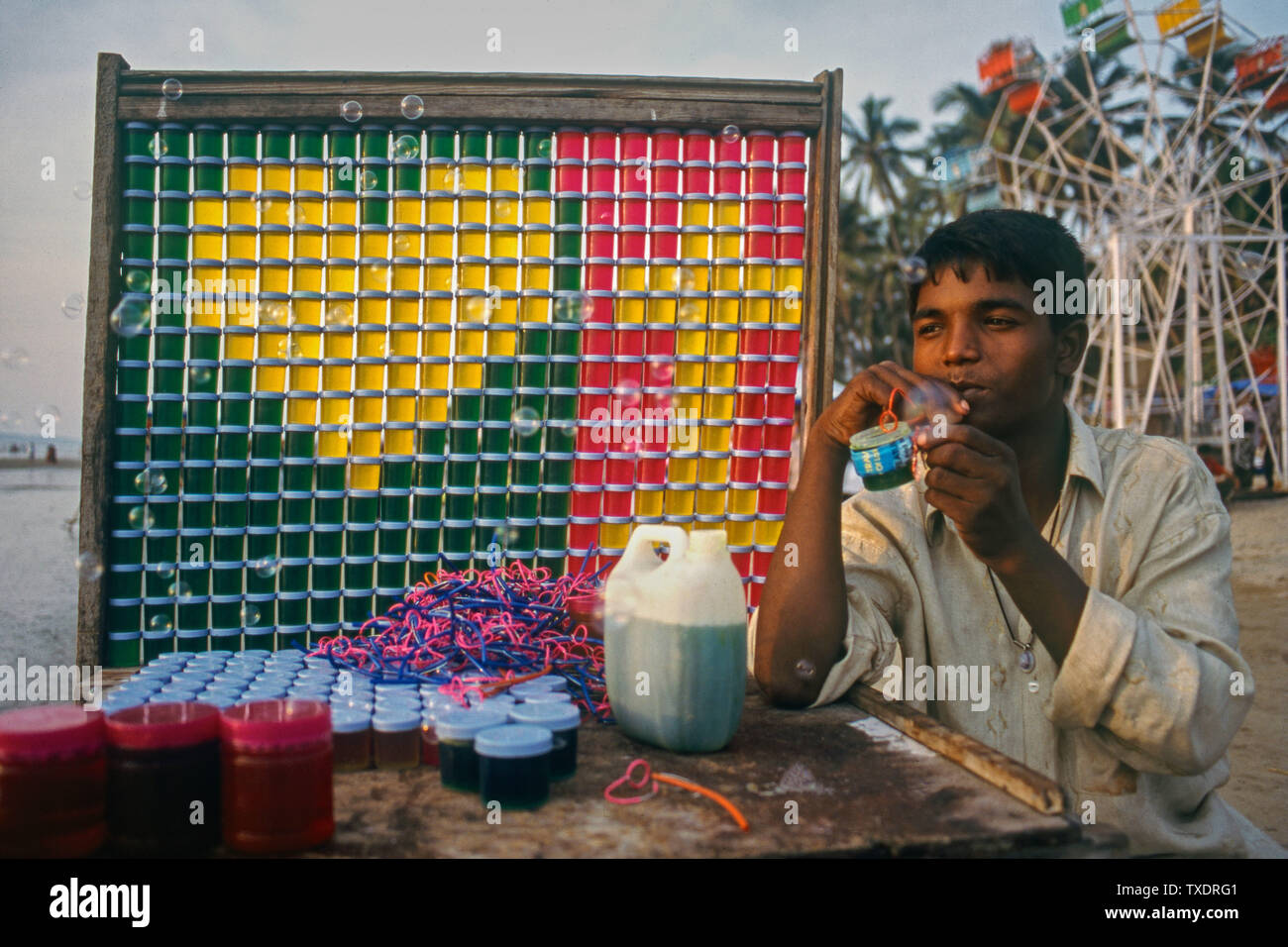 Ragazzo la vendita di bolla d'aria liquido di bottiglie impilati, Mumbai, Maharashtra, India, Asia Foto Stock