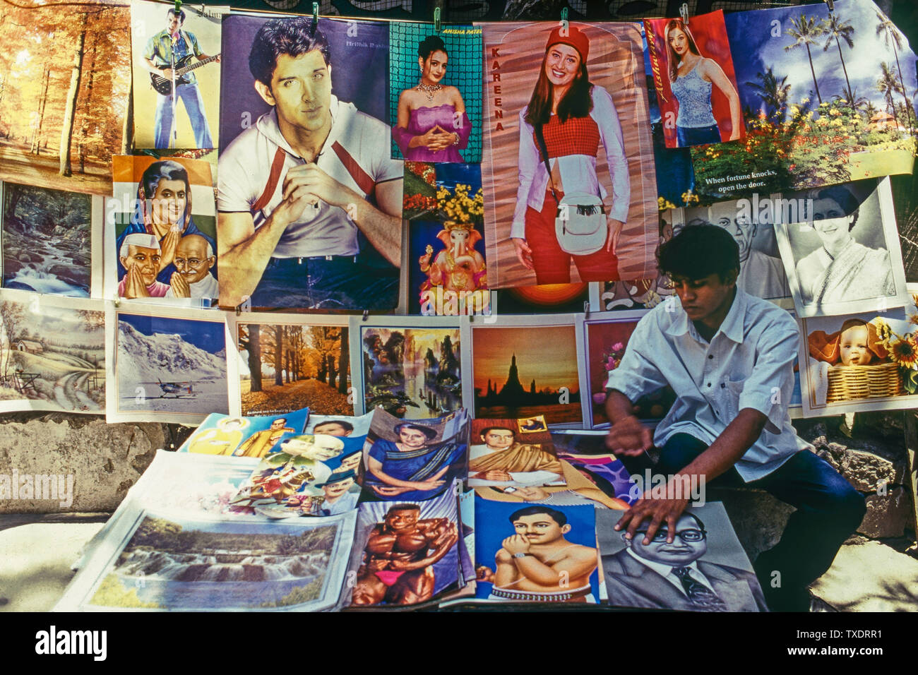 Hawker vendita manifesti di Bollywood gli attori e gli eroi nazionali, Mumbai, India, Asia Foto Stock