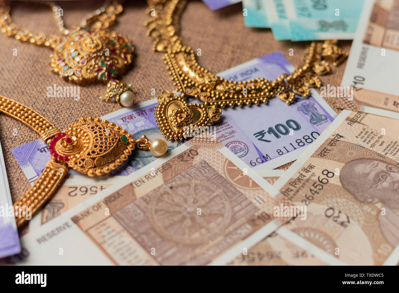 Concetto di denaro nero, raid, confiscato il denaro che mostra la valuta indiana constata con gioielli. Foto Stock