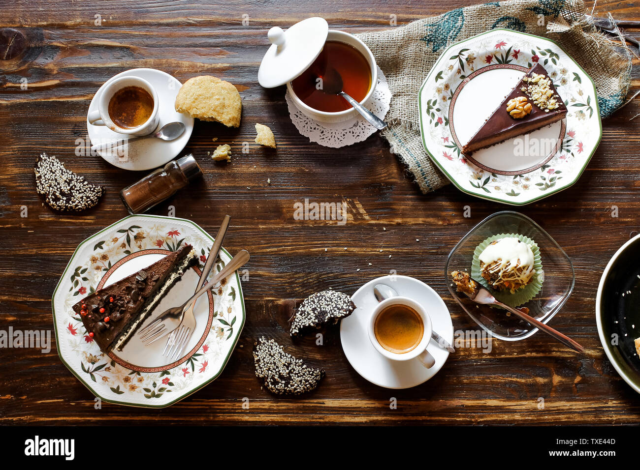 Torte al cioccolato composizione, flatlay, lo spazio negativo, caffè, bicchieri di bianco, piastre floreali, cookie, superficie di legno, prima colazione Foto Stock