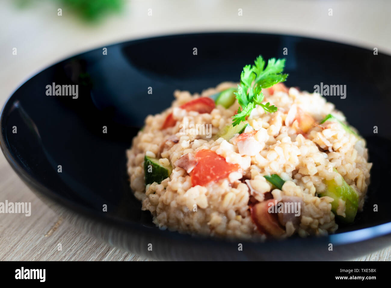 Bulgur con insalata di verdure sul tavolo della cucina a base di ingredienti. Arabo cuscus insalata. Foto Stock
