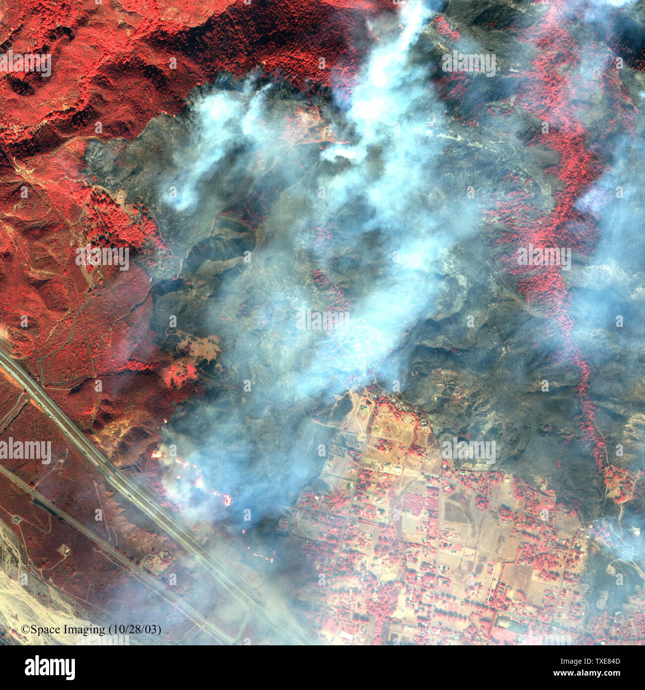 Immagine satellitare della Devore altezze nella zona della contea di San Bernardino, vicino all'intersezione della I-15 e I-215. Devore Heights si trova appena a nord di Lytle Creek area e si trova a 12 miglia a ovest di Lake Arrowhead. Immagine è mostrato in falso colore. Prese vicino all'infrarosso dello spettro di luce, il colore rosso brillante aree mostrano effettivamente verde o piante viventi. Il annerite o aree cariche al centro dell'immagine mostra le aree che sono state bruciate dal wildfire. Grandi le fiamme possono essere vedere lungo il lato nord della I-15 nella parte inferiore dell'immagine. Immagine è stata presa su 28 Ottobre, 2003. (UPI/Spazio immagine) Foto Stock