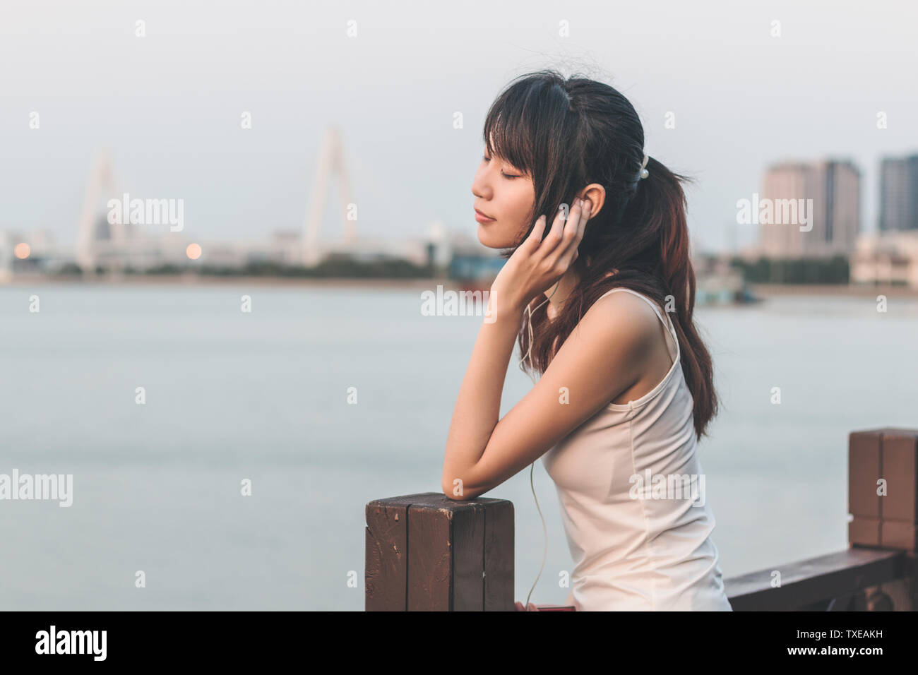 Una ragazza di ascolto di musica dal mare. Foto Stock