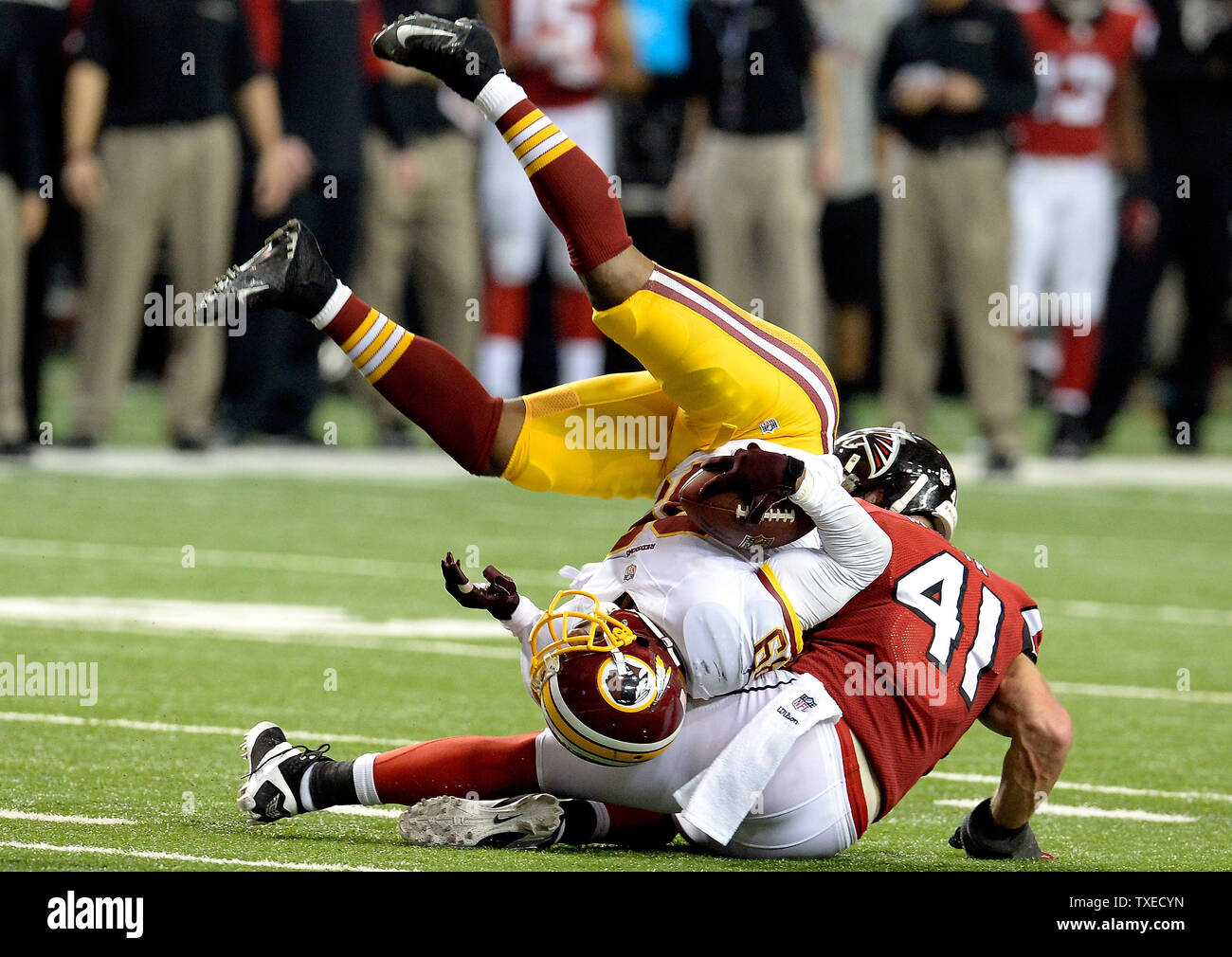 Washington Redskins wide receiver Santana Moss (89) viene ribaltato da Atlanta Falcons sicurezza Zeke Motta (41) dopo il primo verso il basso la reception durante il secondo semestre presso il Georgia Dome di Atlanta su dicembre 15, 2013. Atlanta ha vinto il gioco 27-26. UPI/David Tulis Foto Stock