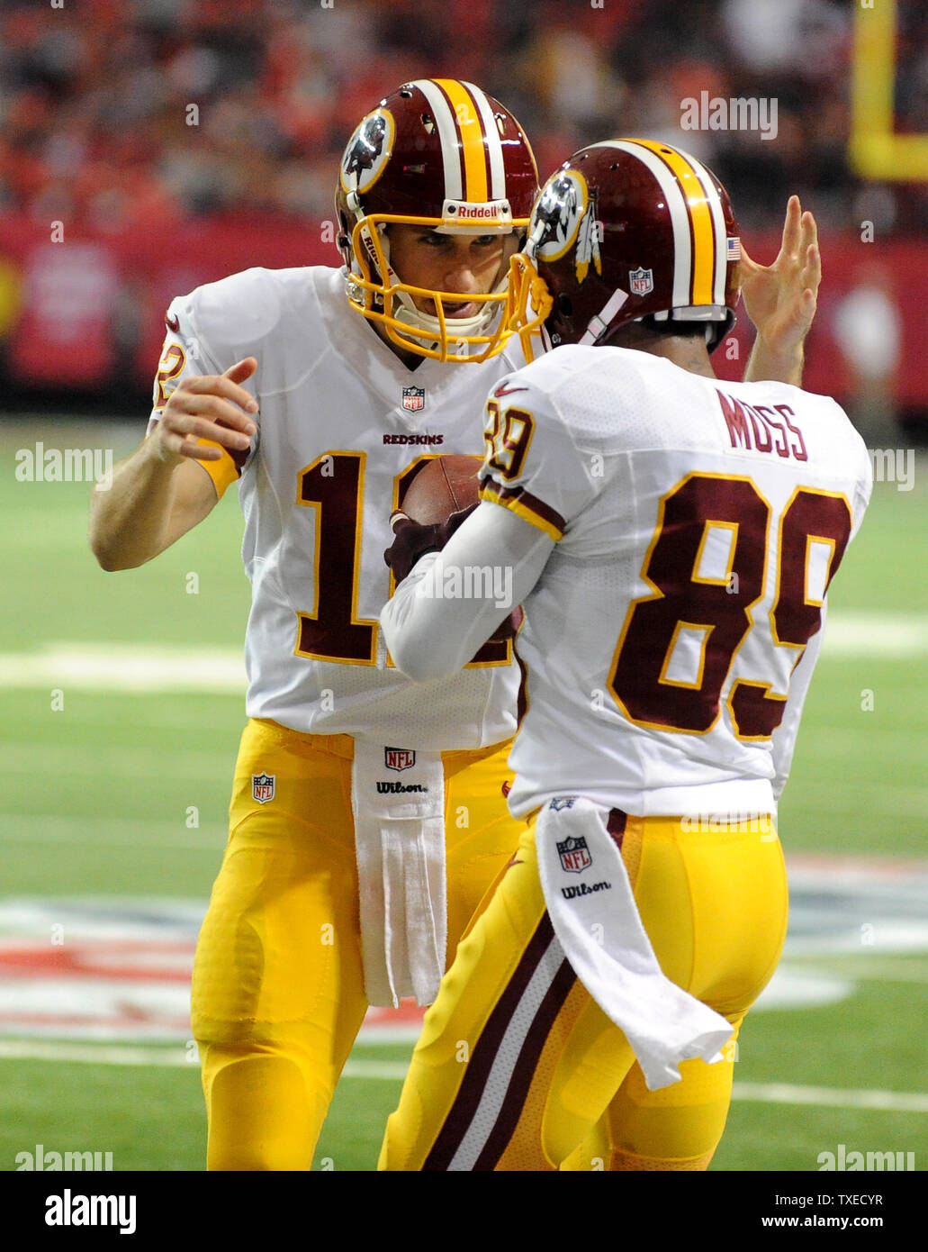 Washington Redskins quarterback Kirk cugini (12) e ricevente larga Santana Moss (89) celebrano il loro 3-cantiere touchdown durante il secondo semestre presso il Georgia Dome di Atlanta su dicembre 15, 2013. Atlanta ha vinto il gioco 27-26. UPI/David Tulis Foto Stock